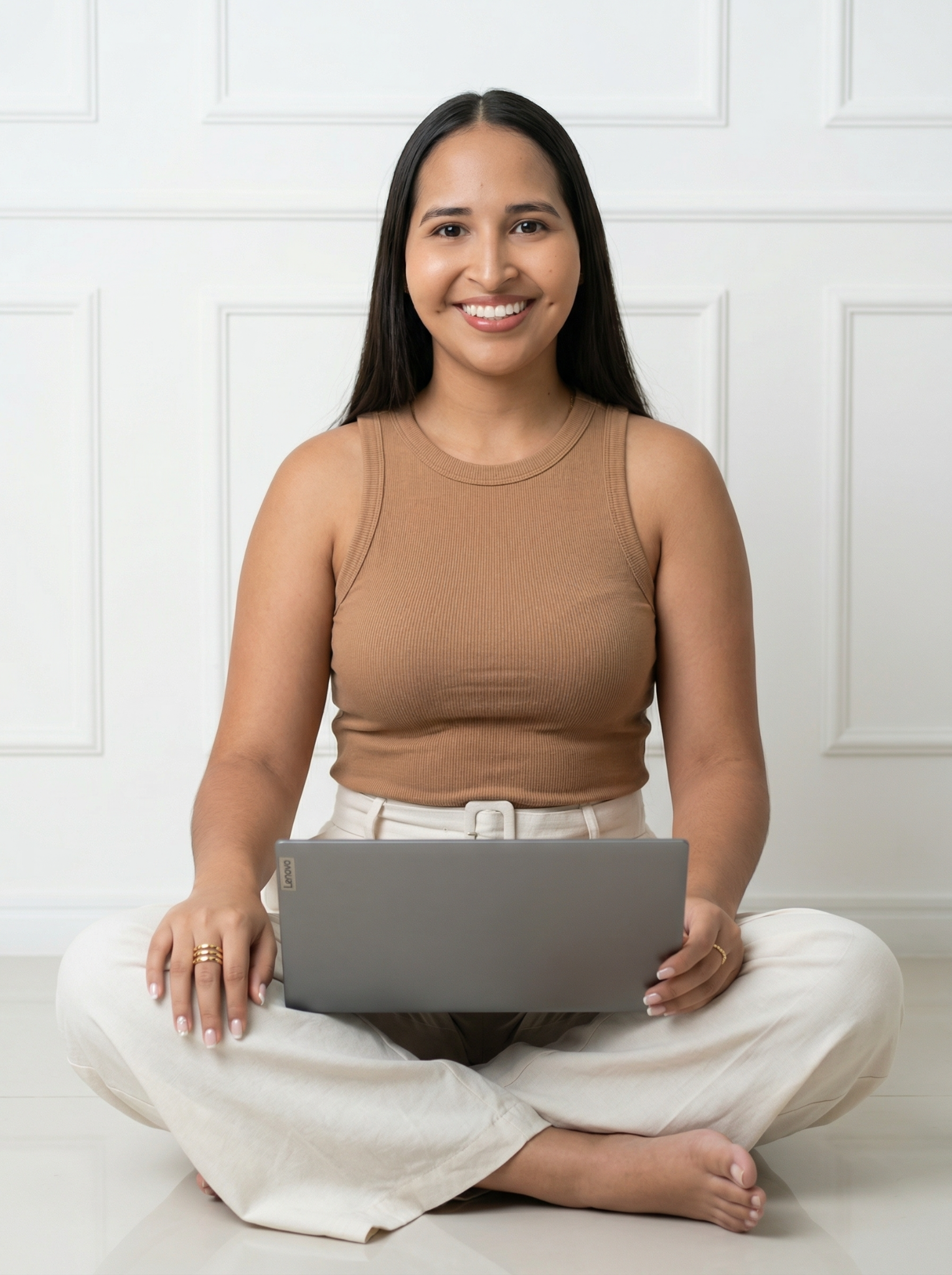 Mariana Mejías, profesora de inglés, sonriendo mientras sostiene su laptop